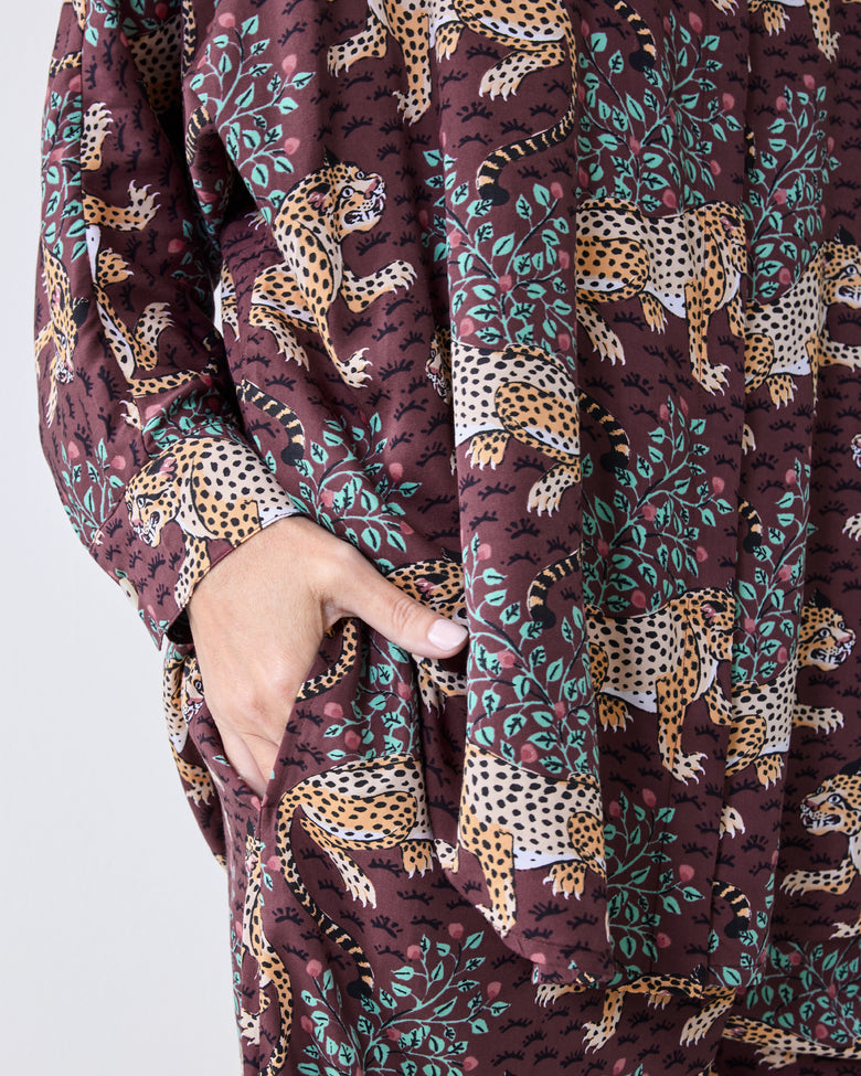 Close-up of the raisin pajama set showing a leopard-and-leaf print, long sleeve, and side pocket.