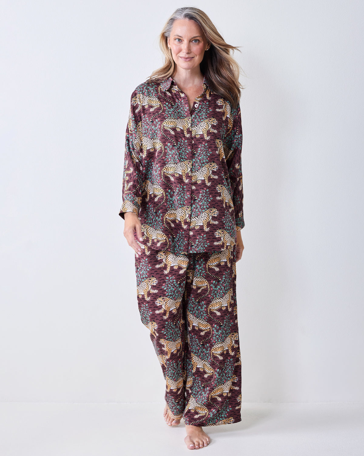 Front view of a leopard-print satin pajama set with a button-front shirt and wide-leg pants.