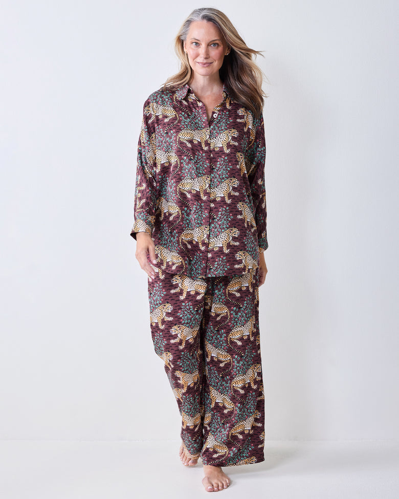 Front view of a leopard-print satin pajama set with a button-front shirt and wide-leg pants.
