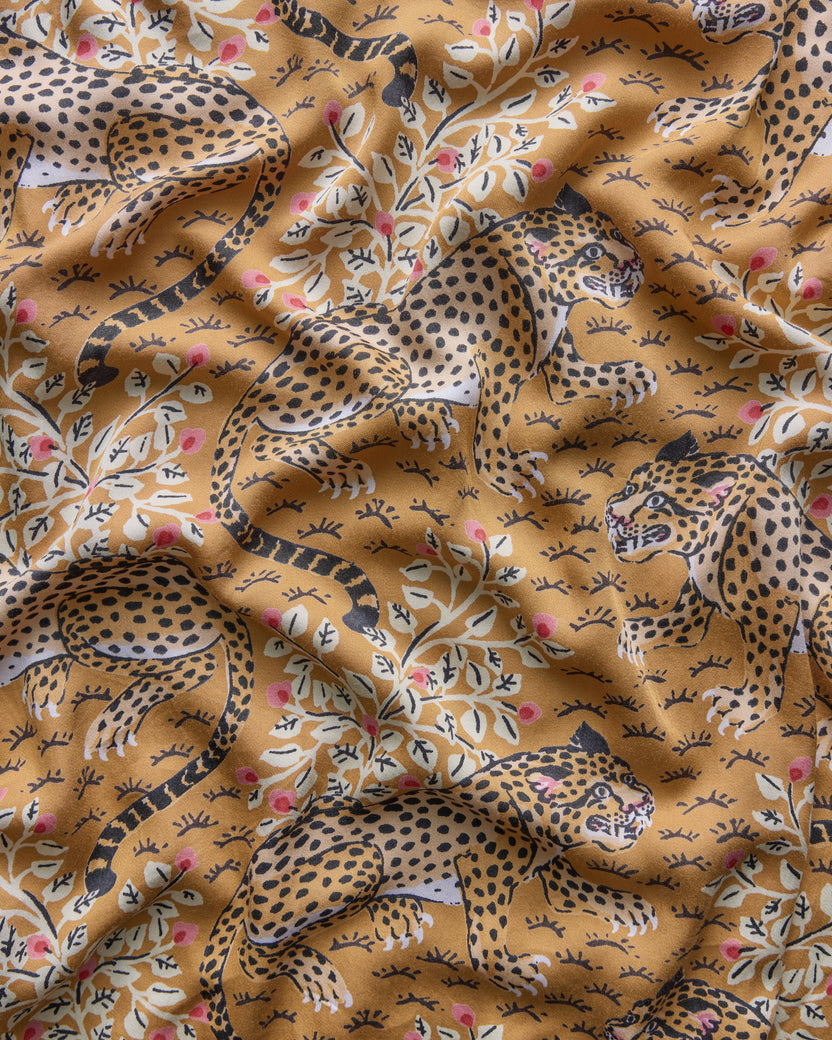 Close-up of the tobacco Bagheera print, featuring spotted leopards and flowering branches.