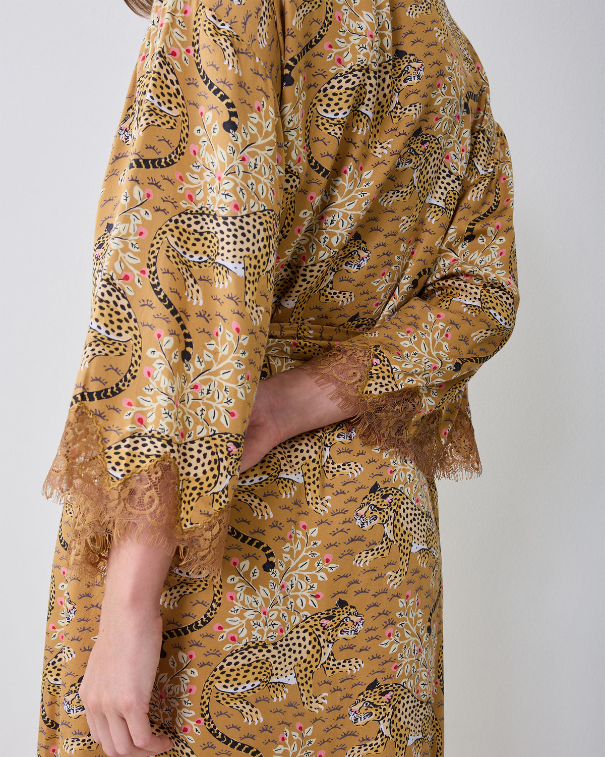 Close side view of the Bagheera Tobacco leopard-print robe showing the lace-trimmed sleeve and matching belt.