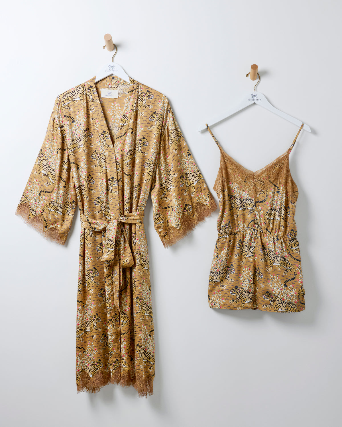 Bagheera robe and matching lace-trim romper hanging side by side in a tobacco leopard print.
