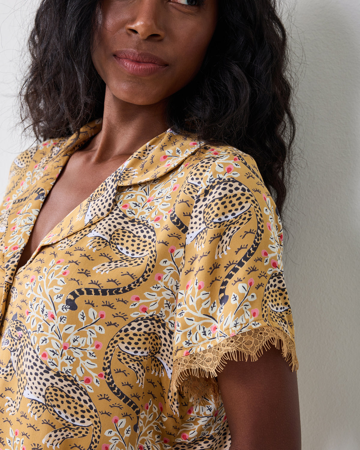 Close-up of the tobacco Bagheera Maryanne set's short-sleeved collared top with leopard-and-floral print and lace sleeve trim.