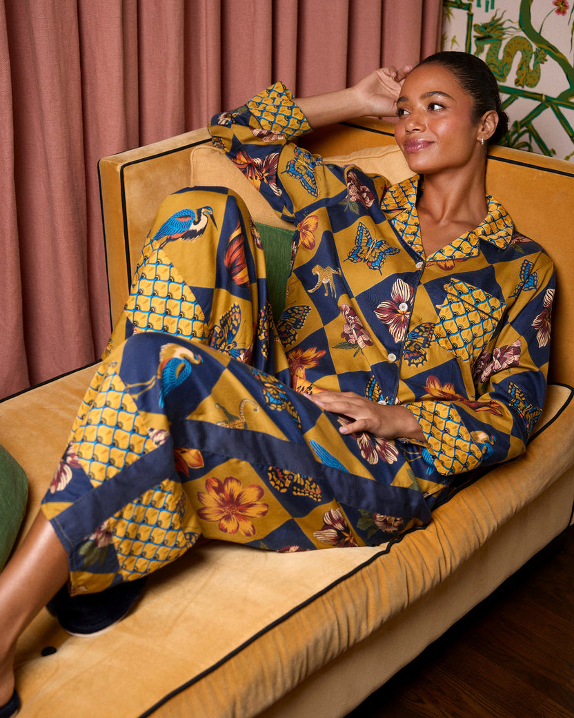 Seated view of a person wearing the Golden Hour Botanical Checkerboard long-sleeved collared top and matching wide-leg pants.