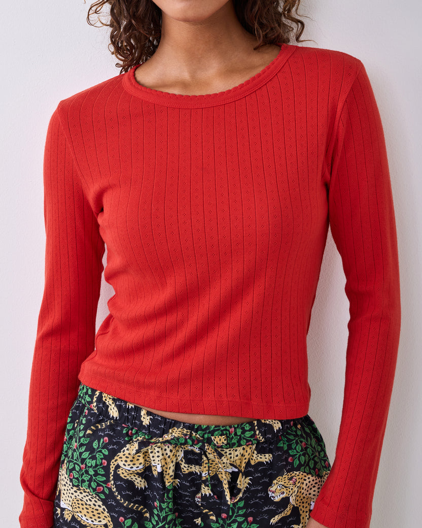 Candy crimson long-sleeve pointelle knit top with a scalloped neckline, shown on a model