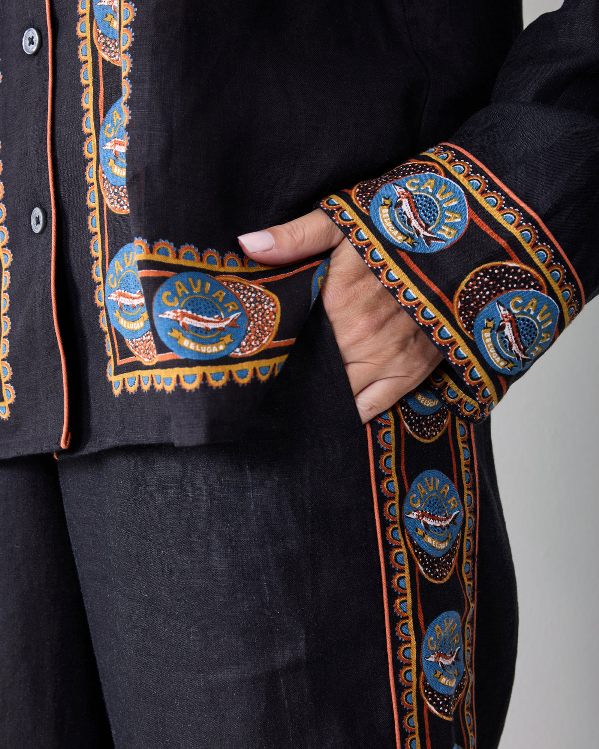Close-up of the black set showing decorative Caviar Reserve border trim on the cuff, pocket, and pant side.