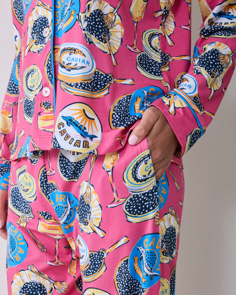 Close-up of the pajama top and matching pants showing the side pocket, cuff, buttons, piping, and Champagne & Caviar print.