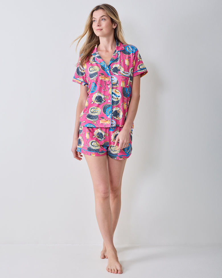 Three-quarter front view of the hot pink Champagne & Caviar short pajama set with a button-front top and shorts.