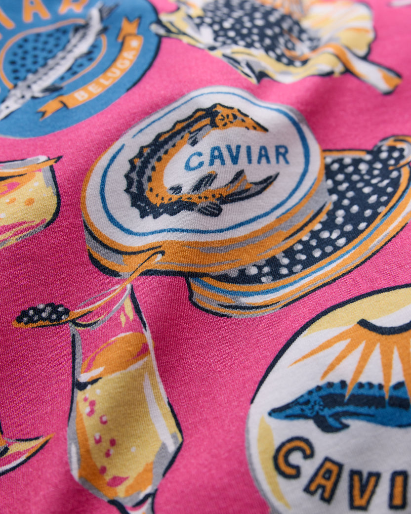 Close-up of the hot pink Champagne & Caviar pajama print with caviar tins and champagne glasses.