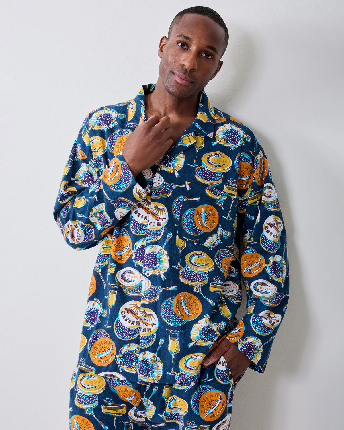 Model wearing the navy Champagne & Caviar long-sleeve pajama shirt with matching pants and a champagne-and-caviar print.
