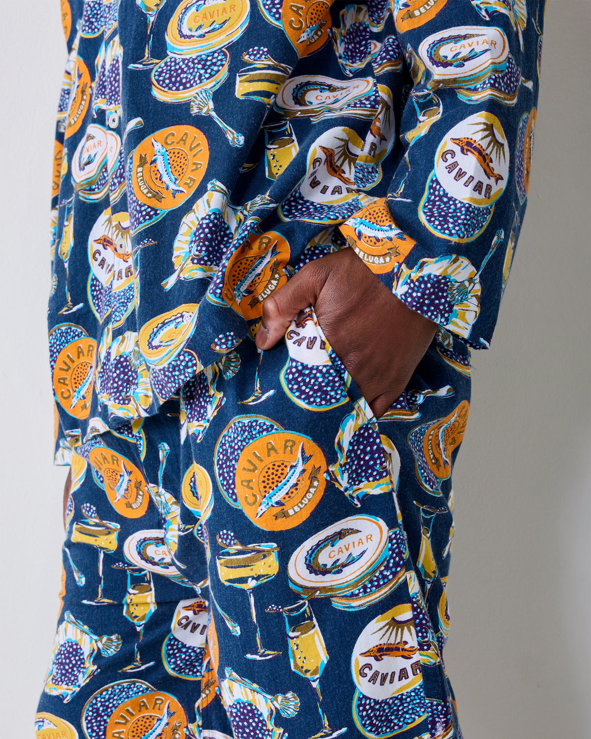 Close-up of the navy Champagne & Caviar pajama set showing the printed fabric and a pants pocket.