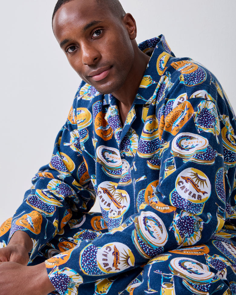 Close-up of the navy Champagne & Caviar pajama top showing its collar, buttons, and printed caviar design.