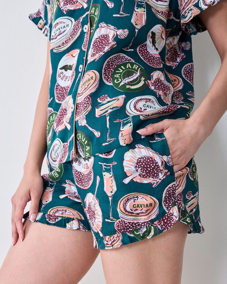 Close-up of the caviar-print pajama top and shorts, showing a side pocket and ruffled shorts hem.