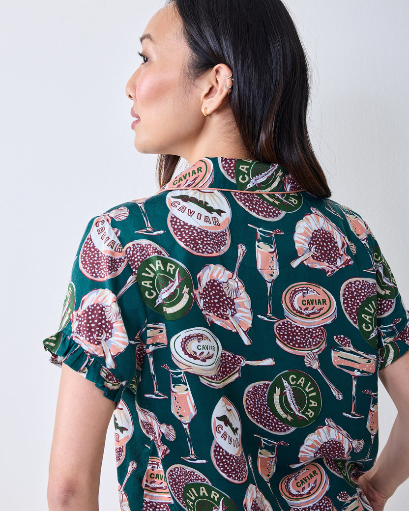 Close back view of the satin pajama top, showing the collar, ruffled sleeve edge, and caviar-themed print.