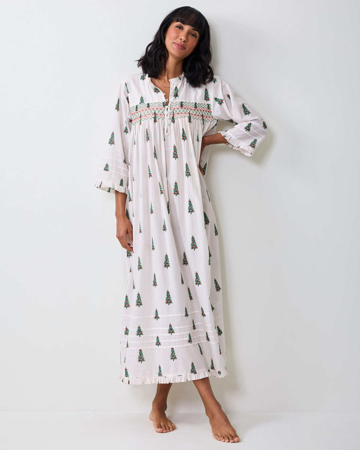 Full-length view of the Sweet Cream Dreamscape Nightgown with repeated Christmas tree motifs, a button neckline, wide three-quarter sleeves, and a flounced midi-length hem.