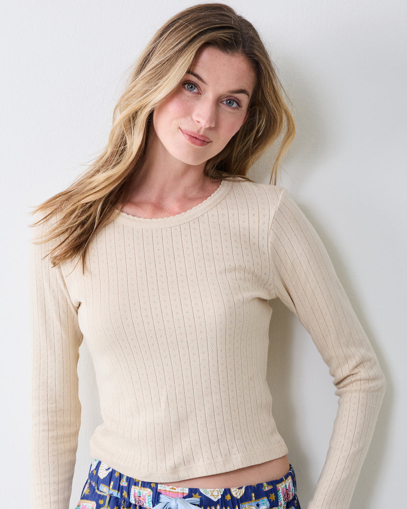 Close front view highlighting the cool ecru pointelle texture and scalloped neckline of the long-sleeve top.