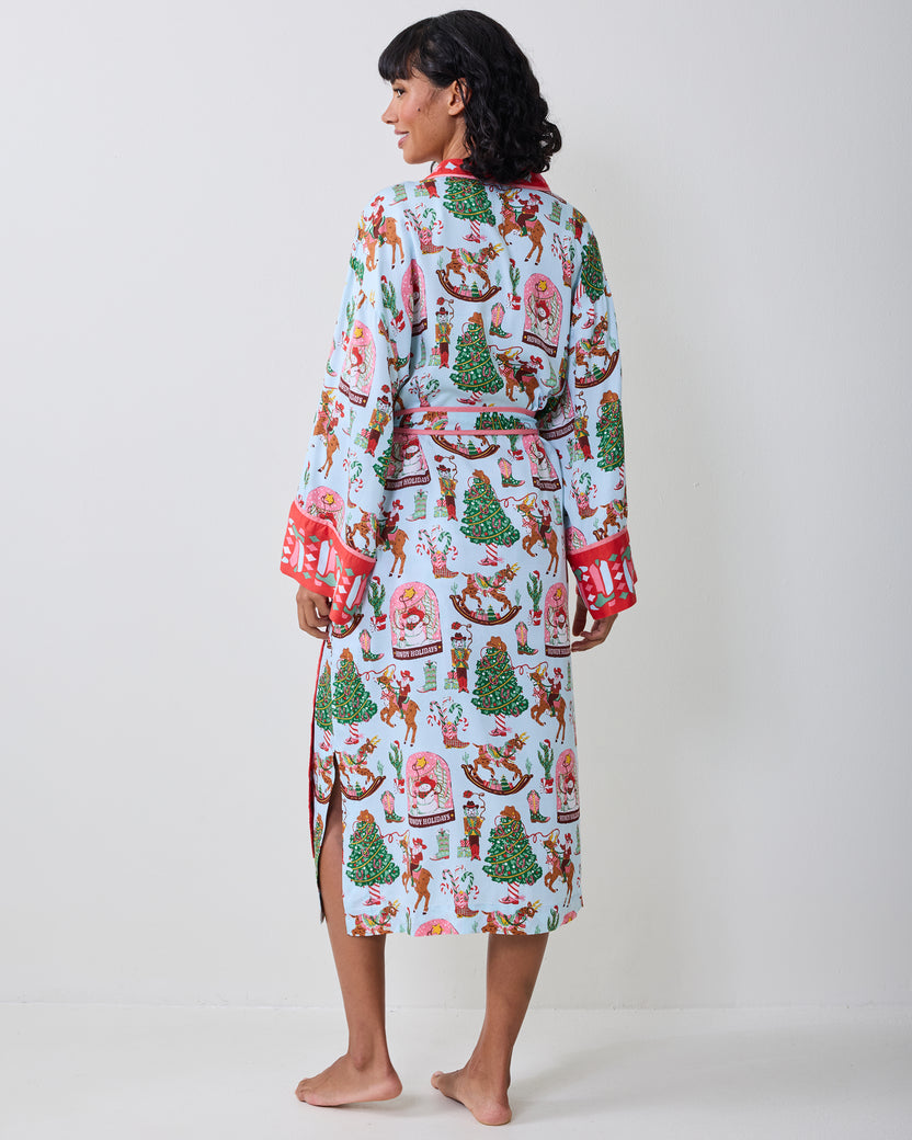 Back view of the pale blue Cowboy Christmas robe showing the holiday print, waist tie, red cuff trim, and side slit.