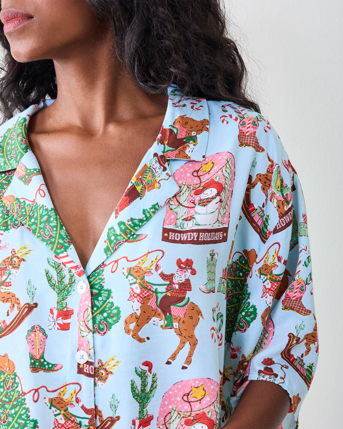 Close-up of the button-down top showing the Cowboy Christmas print, collar, and front buttons.