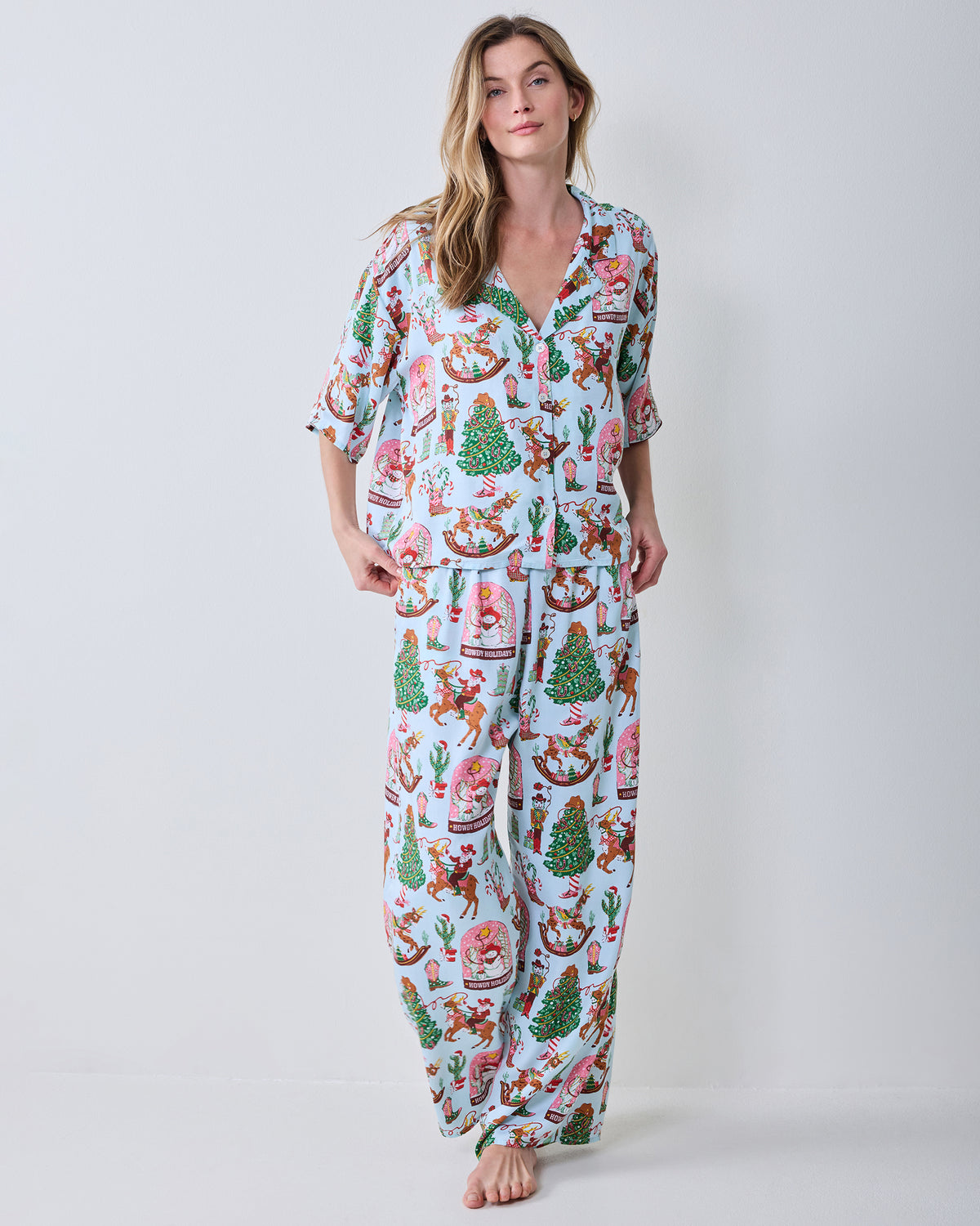 Front view of the short-sleeve button-down top and wide-leg pants in the Cowboy Christmas print.