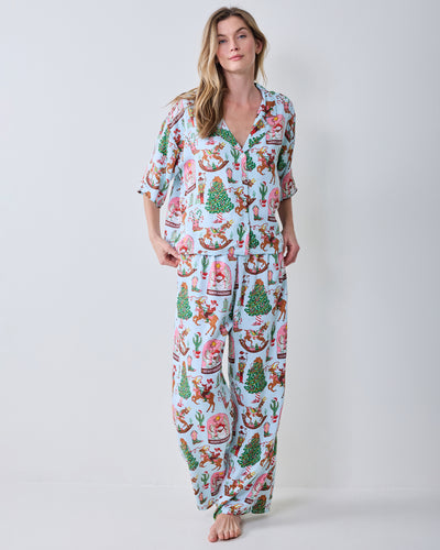 Front view of the short-sleeve button-down top and wide-leg pants in the Cowboy Christmas print.