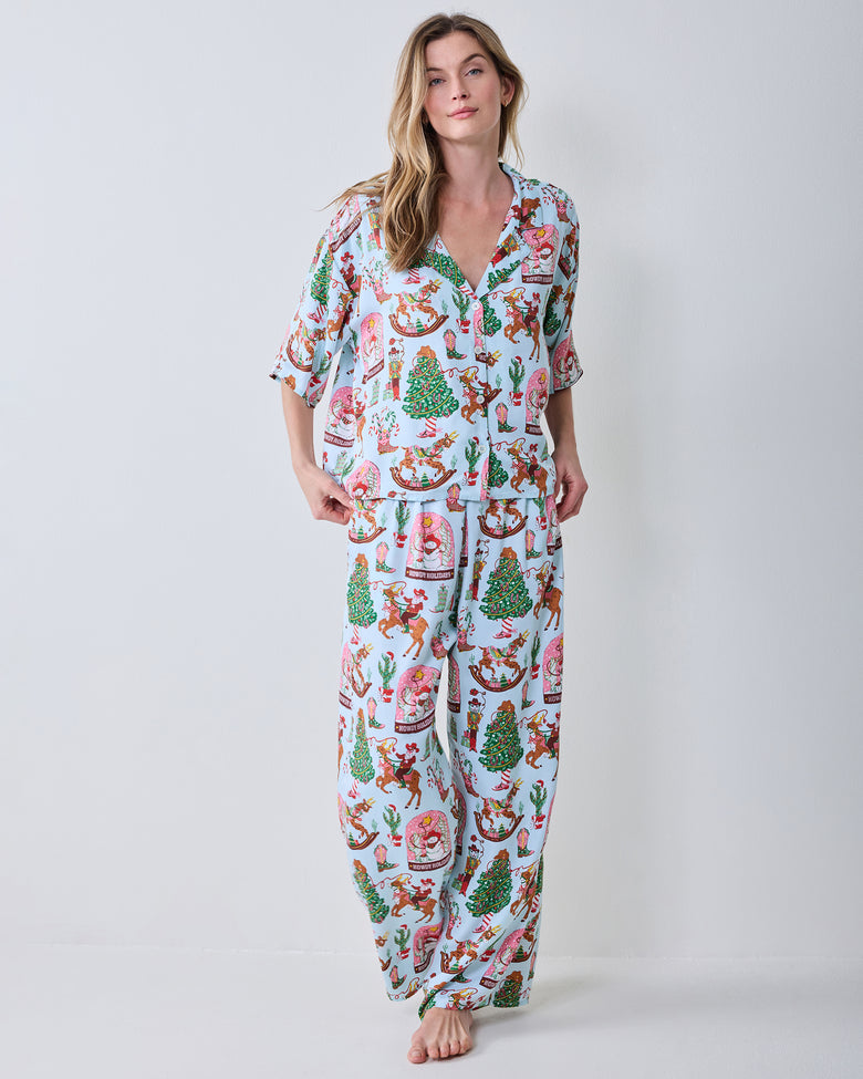 Front view of the short-sleeve button-down top and wide-leg pants in the Cowboy Christmas print.