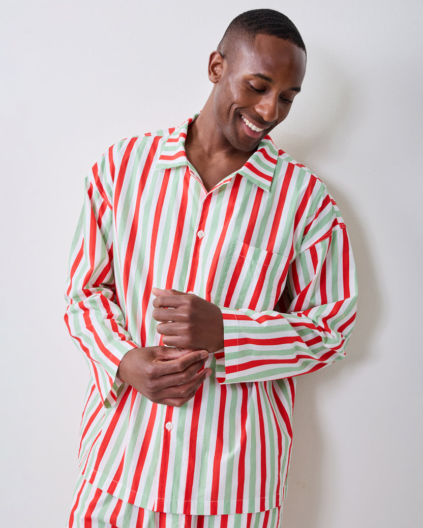 Person wearing the Elf Stripes men's long pajama set with vertical sage and cherry stripes, shown from the front.