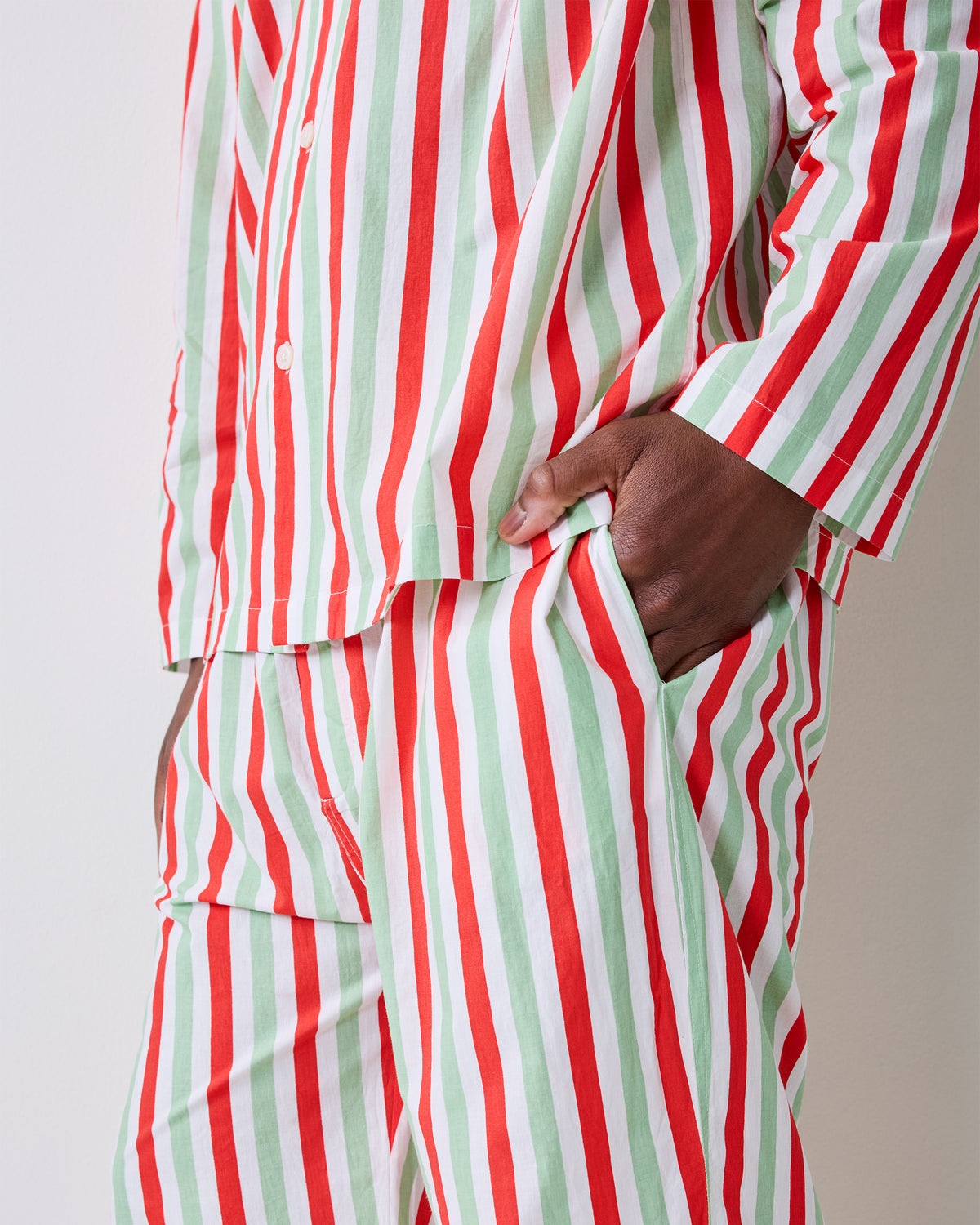 Close-up of the Elf Stripes sage and cherry pajama set showing the button-front top, waistband, and side pocket.