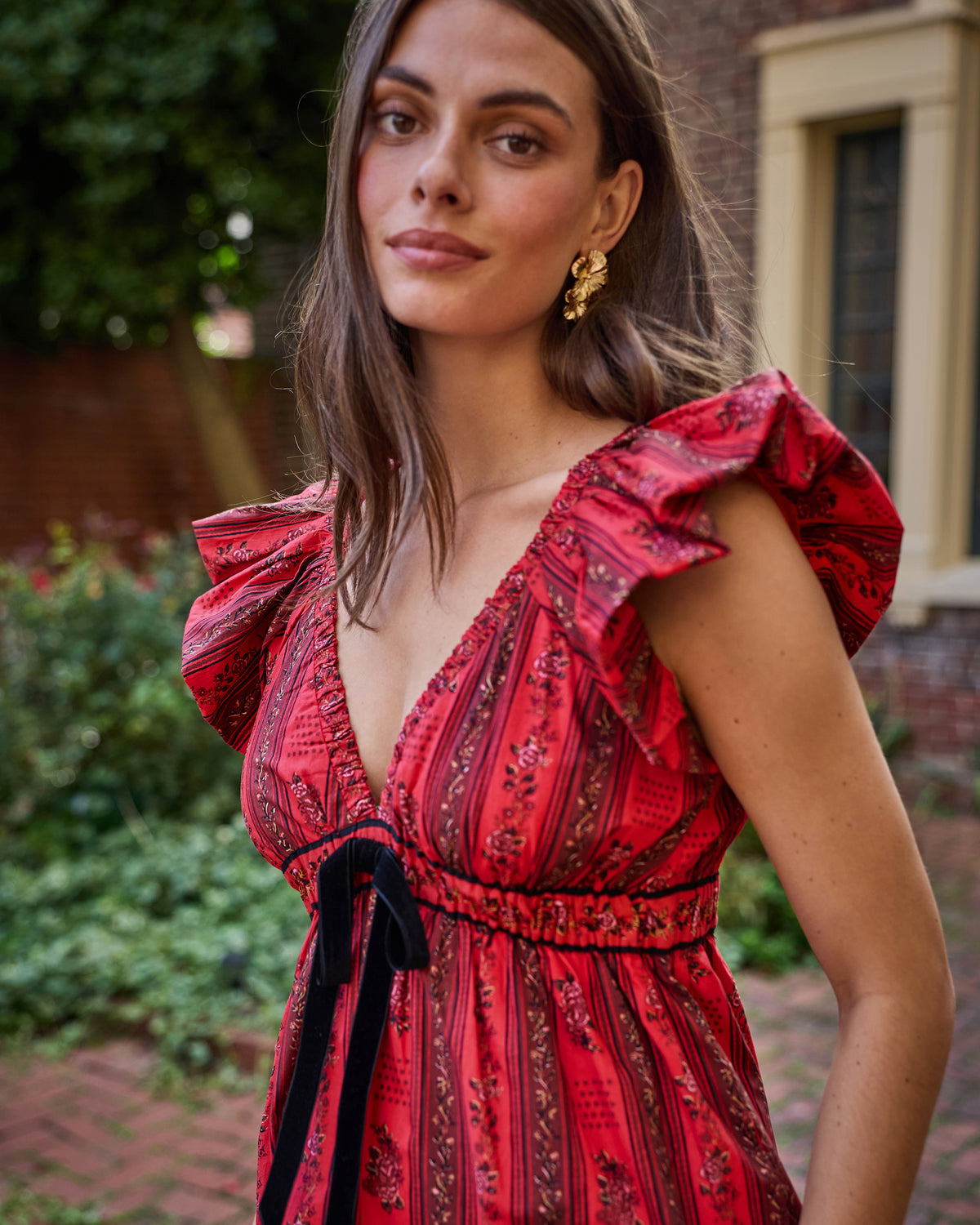 Close view of the Heirloom Red Festive Roses Cecily dress with ruffled sleeves, a V-neckline, and a waist tie.