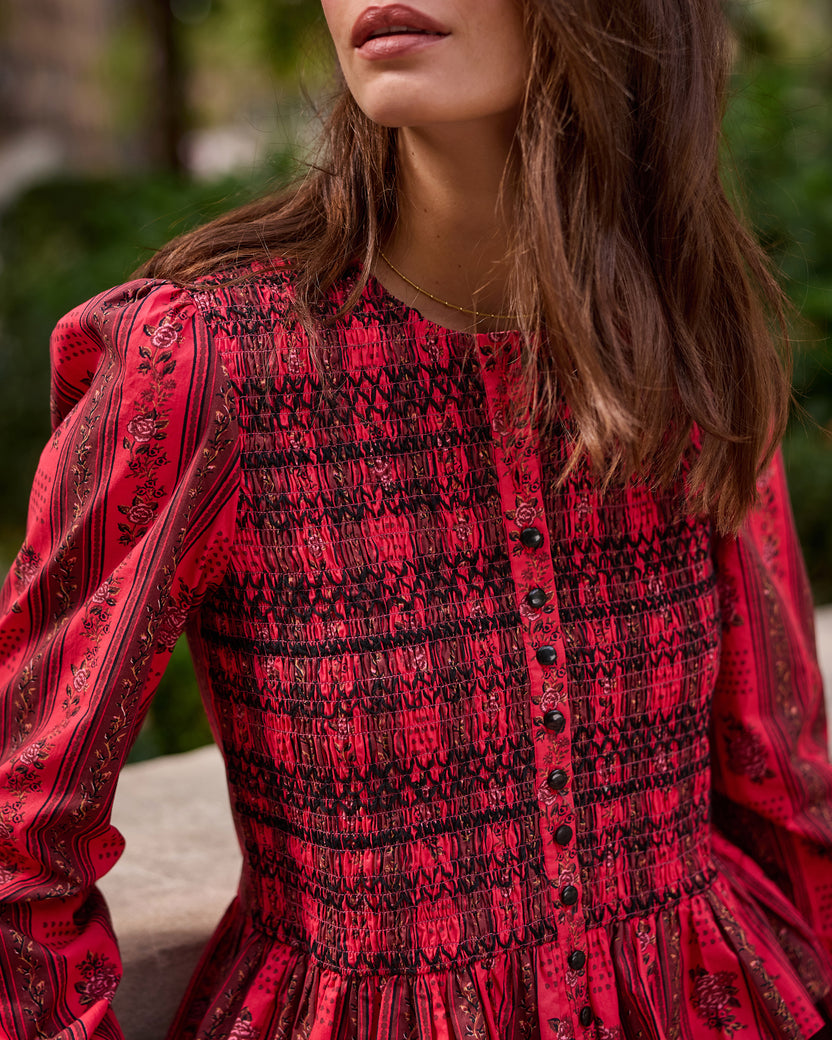 Close-up of the Heirloom Red Festive Roses Lavelle blouse showing its smocked bodice, black buttons, floral pattern, and puffed sleeve.
