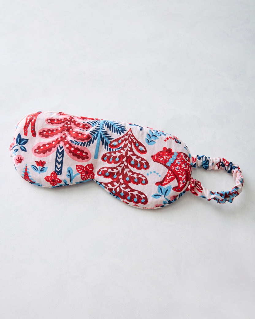 Cream eye mask with red and blue woodland-pattern print and an elastic strap.
