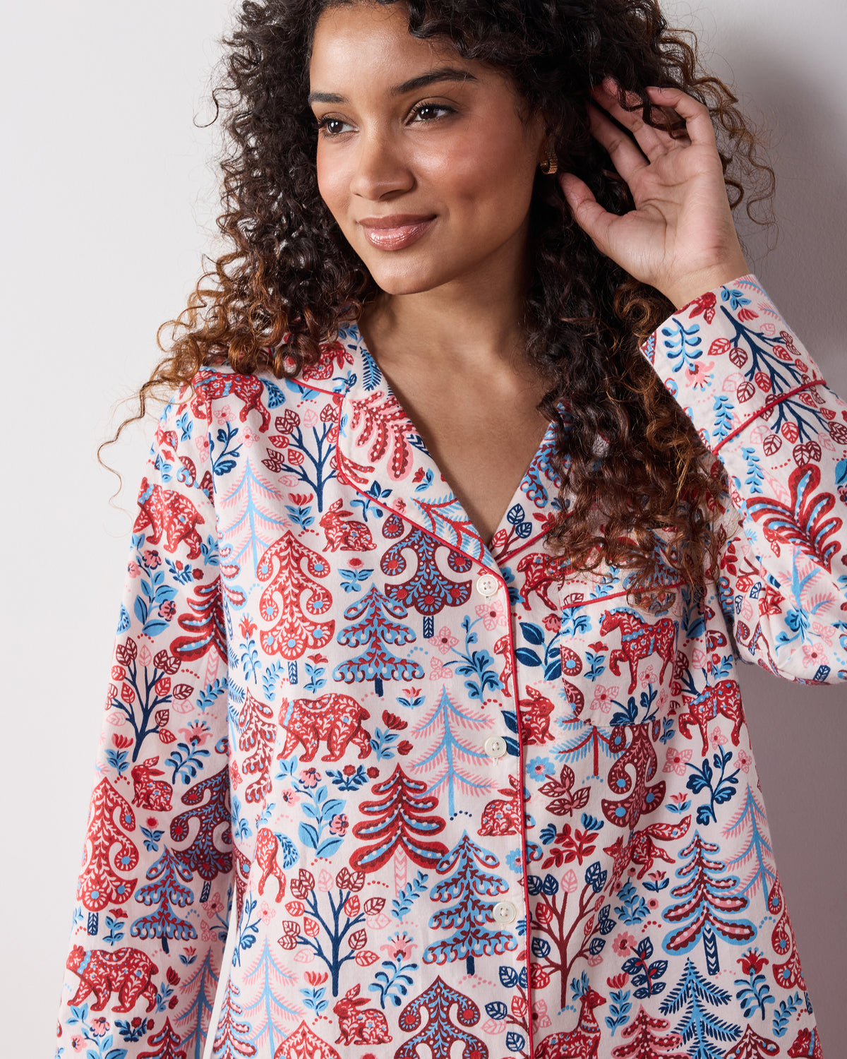 Front view of the cream Folklore Forest long pajama set with a button-front collared top and red, blue, and pink forest-inspired print.