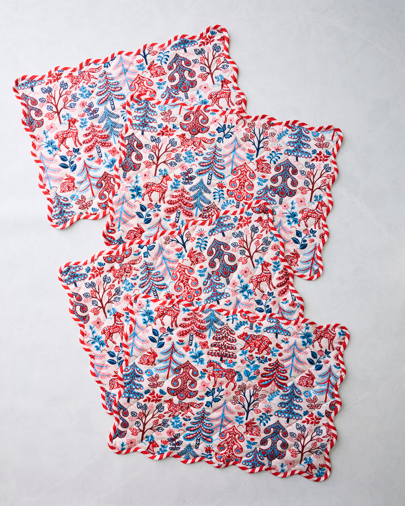 Four Folklore Forest placemats with scalloped edges arranged in an overlapping stack.