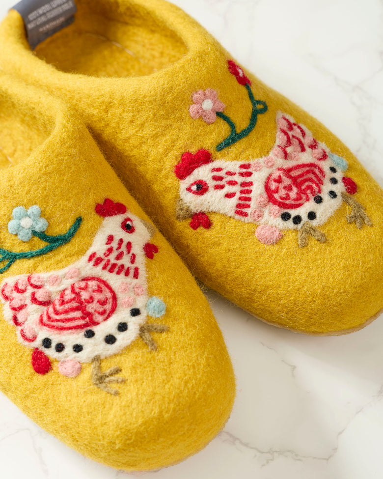 Close-up of yellow Holiday Hens slippers with hand-felted hen and flower details.