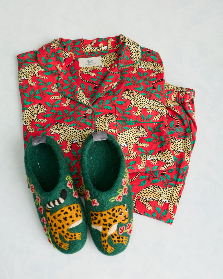 Green Winter Holly Bagheera slippers displayed with a red leopard-print pajama set.