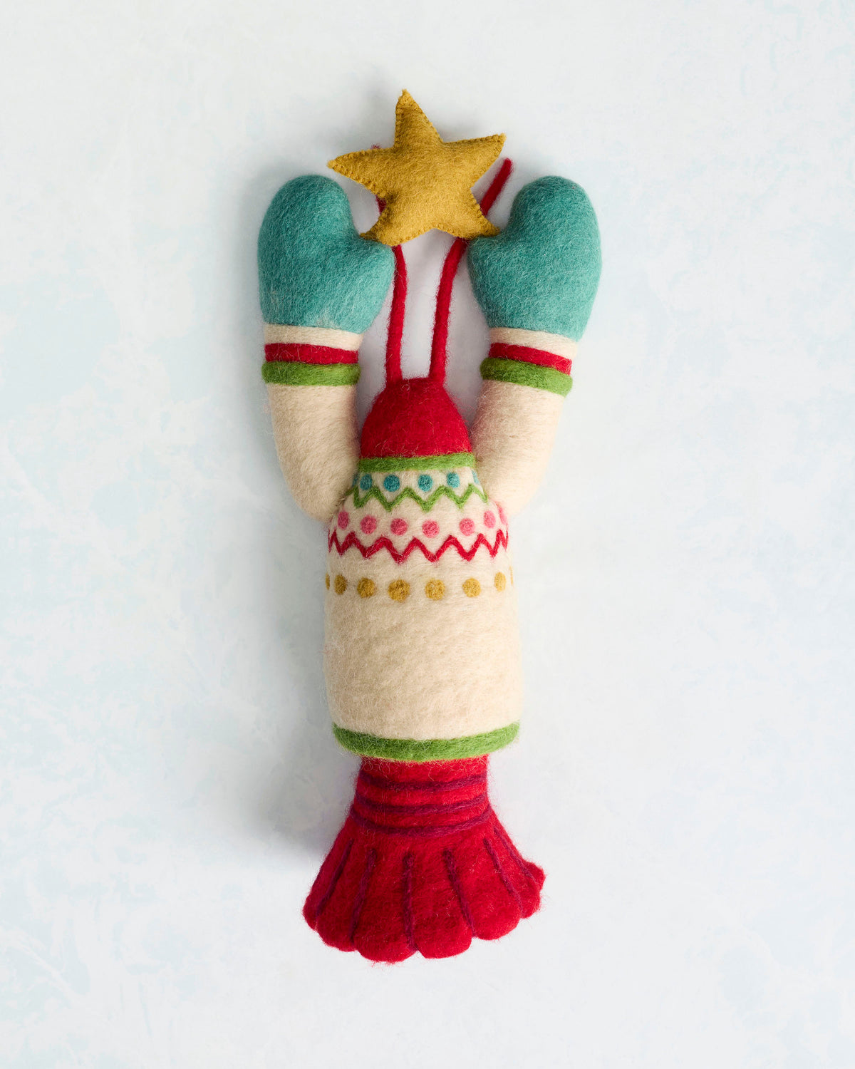 Felted lobster tree topper with teal claws, a yellow star, red body, and patterned cream section.
