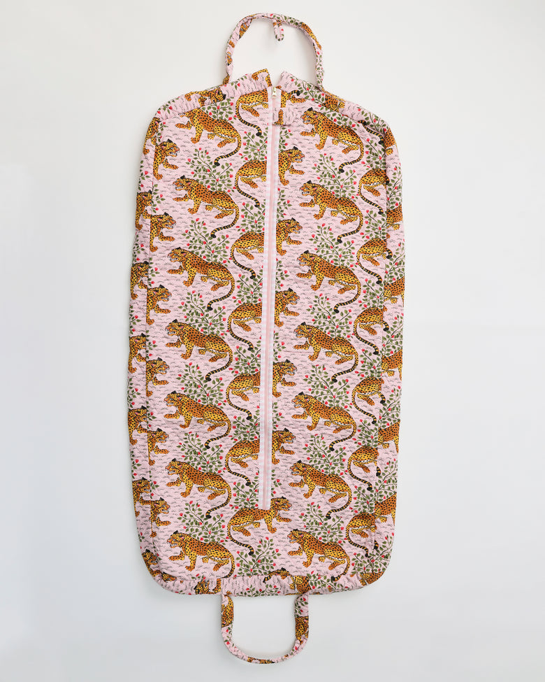 Flat view of the Bagheera blush garment bag with a front zipper, top hanger loop, bottom handle, and leopard-and-botanical print.