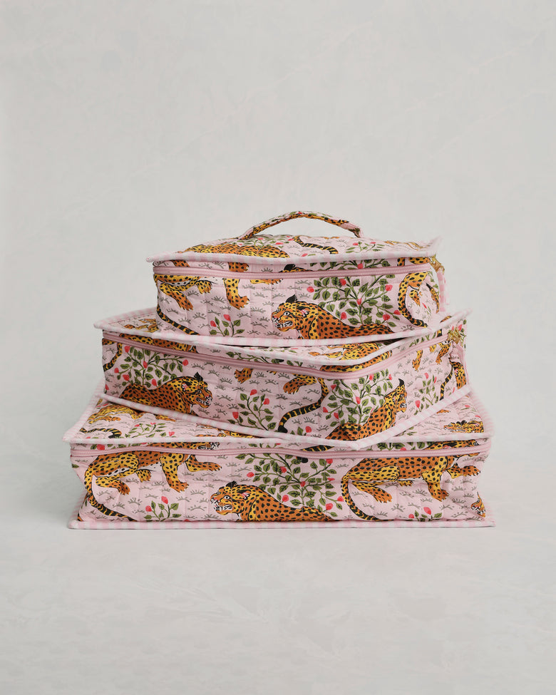Three pink leopard-and-leaf print packing cubes stacked in a front-facing view.