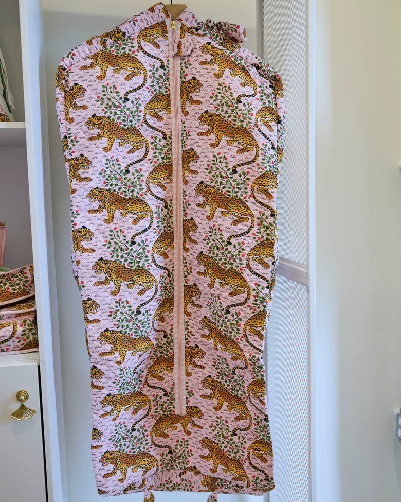 Close front view of the Bagheera blush garment bag with a zipper and leopard-and-botanical print.