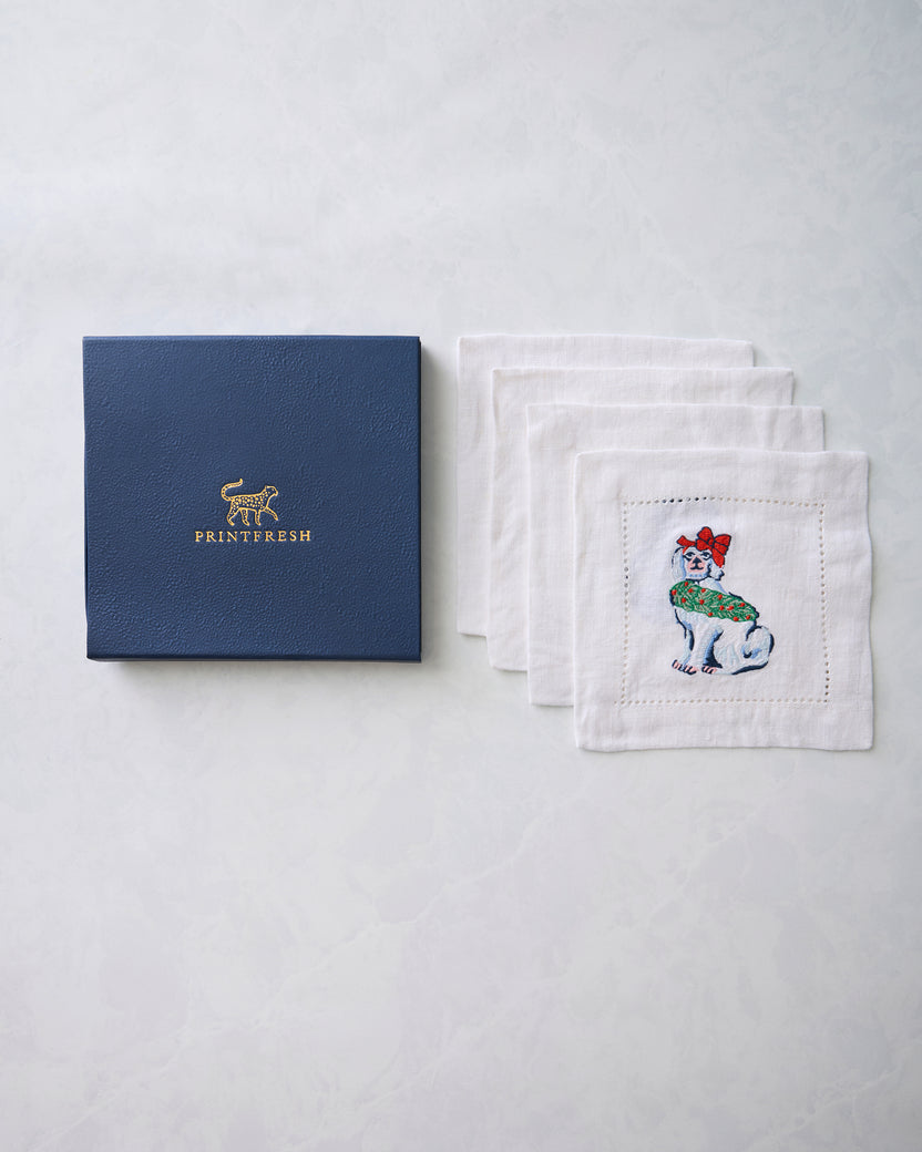 Printfresh box beside four white embroidered Christmas dog cocktail napkins.