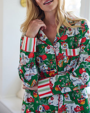 Close-up of the Good Dog Christmas long pajama top, showing the collar, buttons, chest pocket, striped cuffs, and dog-and-poinsettia print.