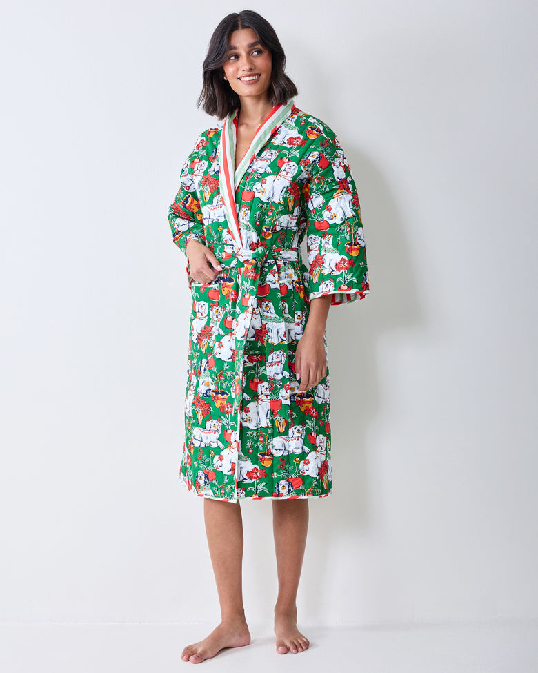 Three-quarter front view of a person wearing a green Christmas dog print robe with striped sleeve lining and a matching belt.