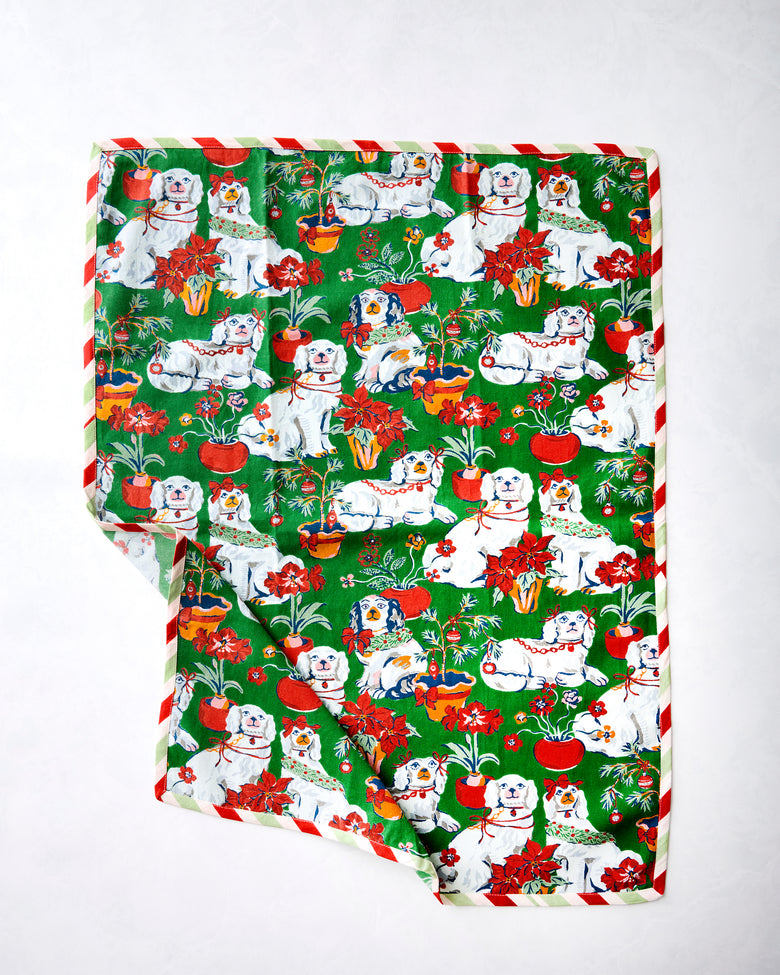 Good Dog Christmas tea towel showing white dogs, red flowers, potted plants, and a red-and-white striped border.