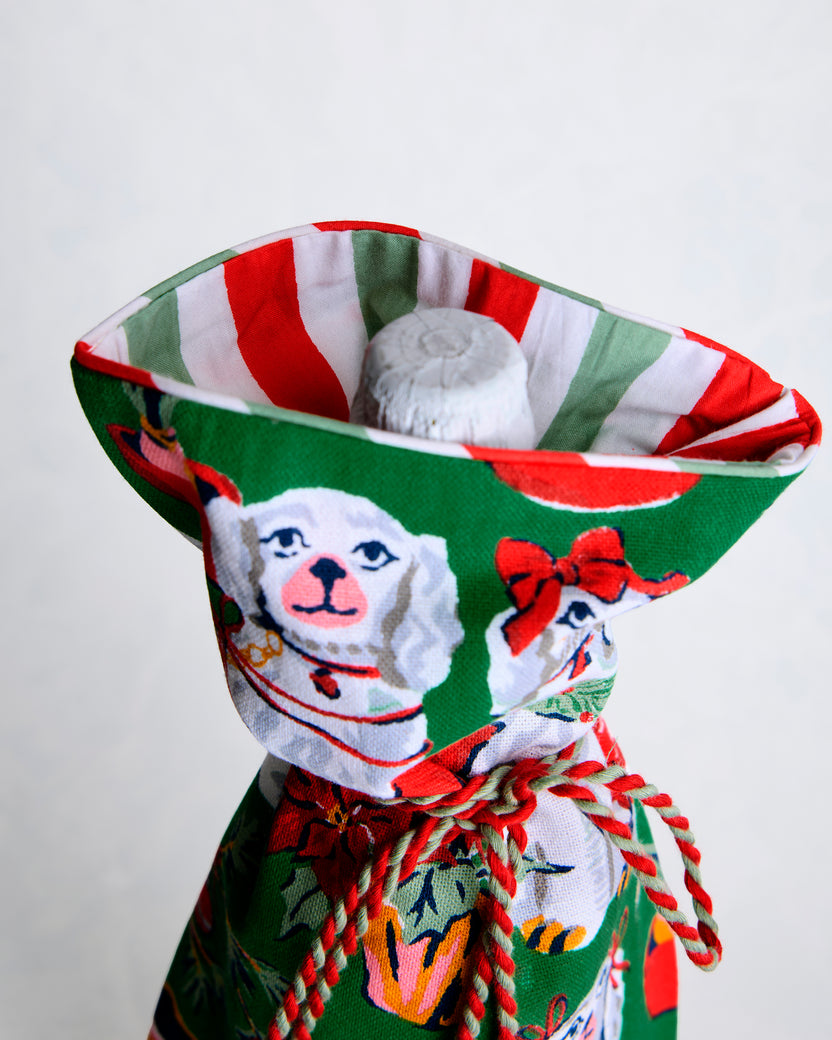 Open green dog-print wine bag showing its red-and-green striped lining and a white bottle neck inside.