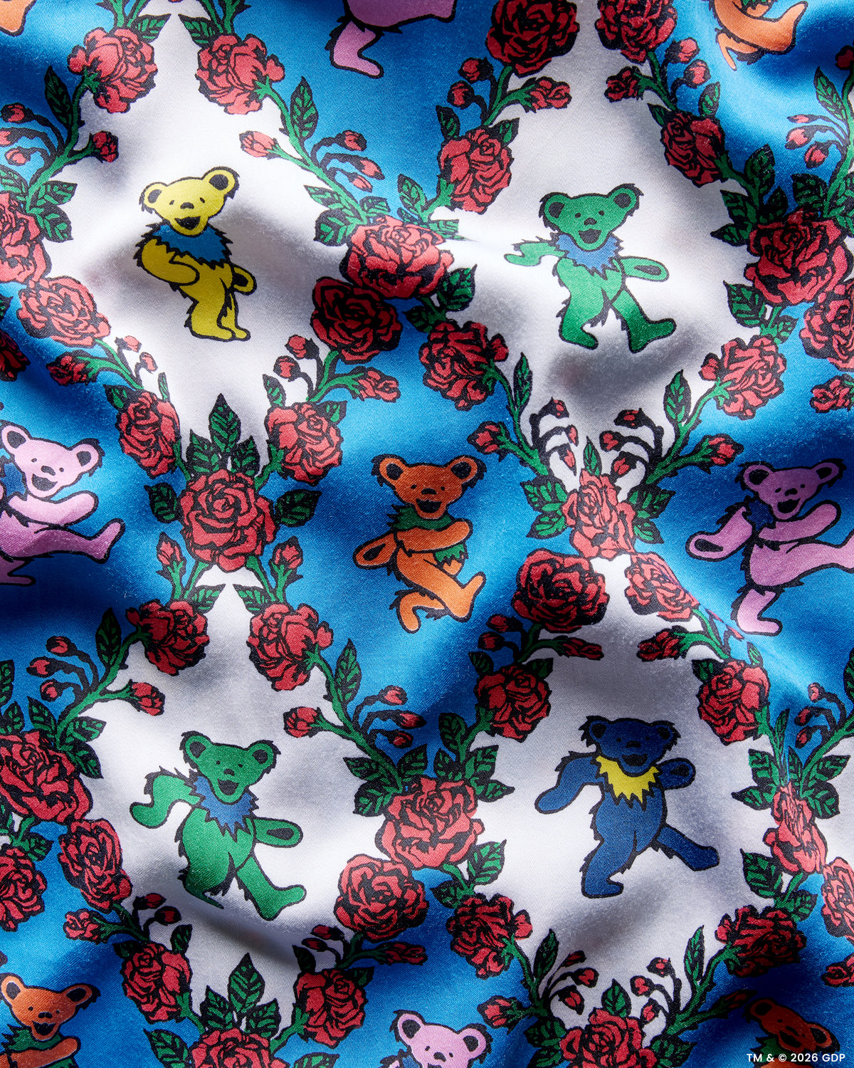 Close-up swatch of the Wandering Rose Palo Alto print with dancing bear figures and roses on blue and white sections.
