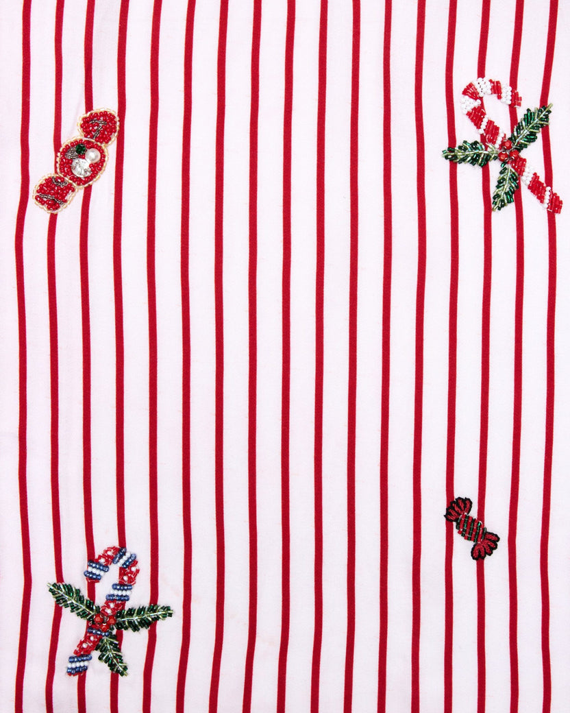 Close-up swatch of the Ellie set pattern with red vertical stripes and embroidered holiday motifs.