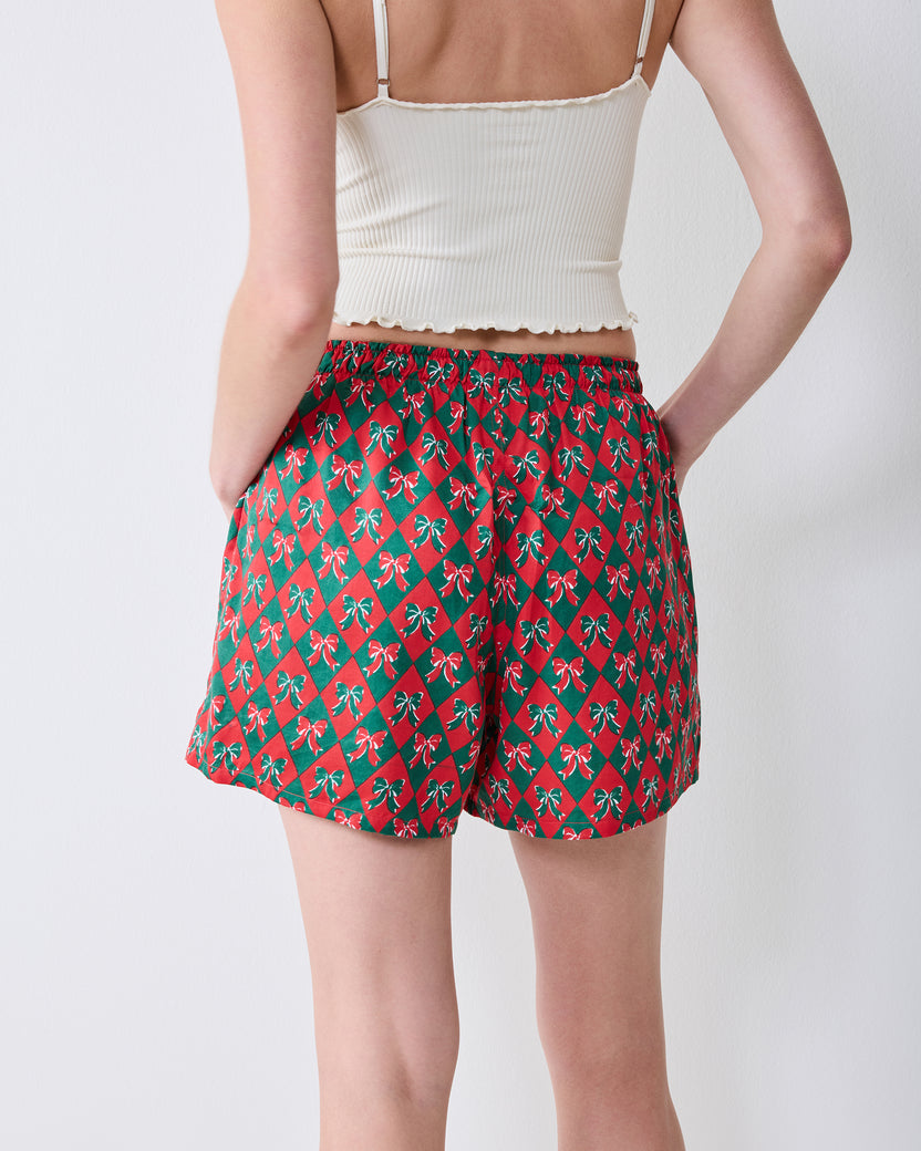 Back view of red boxer shorts with a green argyle and bow print, showing the rear fit and waistband.