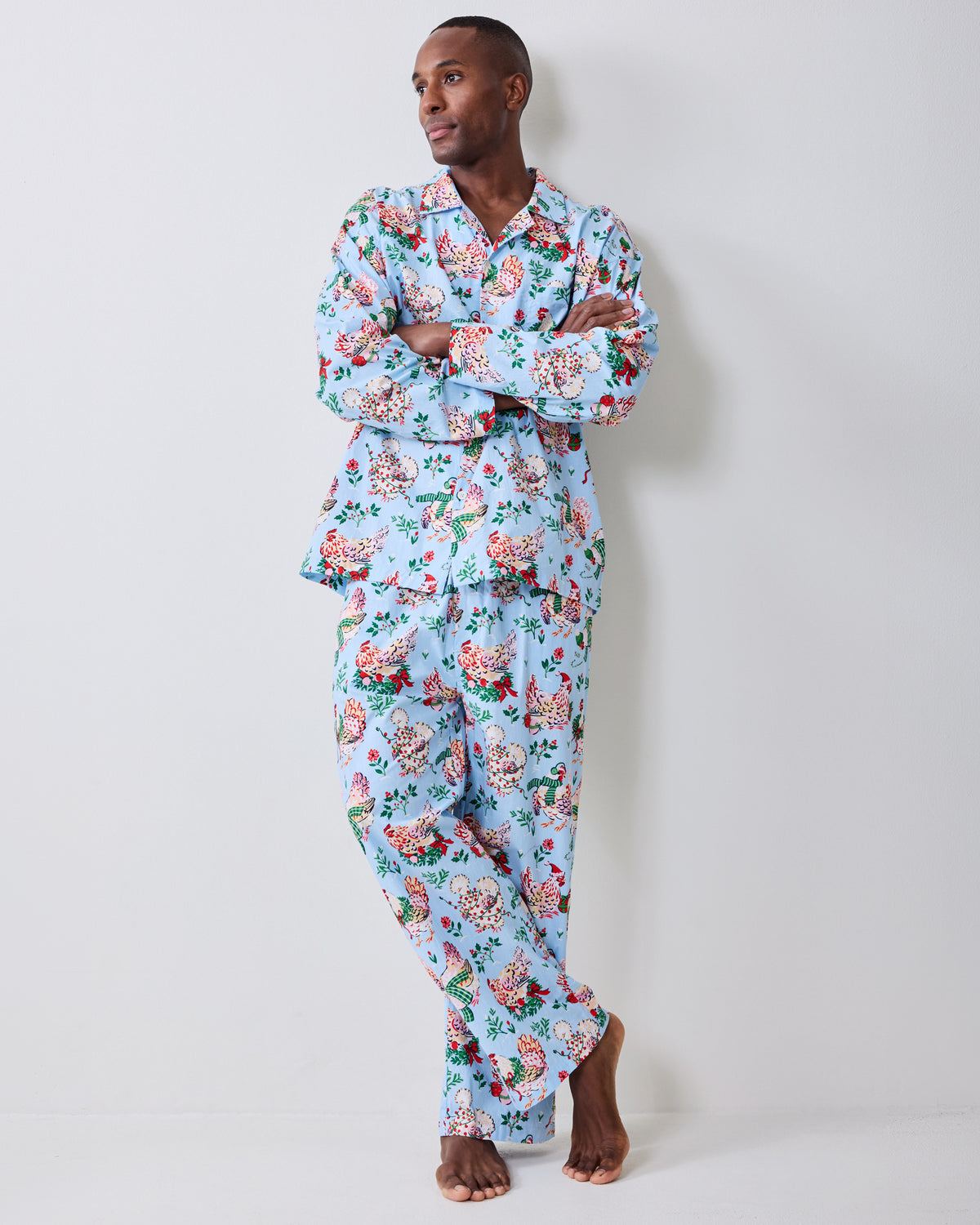 Full-length view of a pale blue holiday hen pajama set with a long-sleeve button-front shirt and pants.