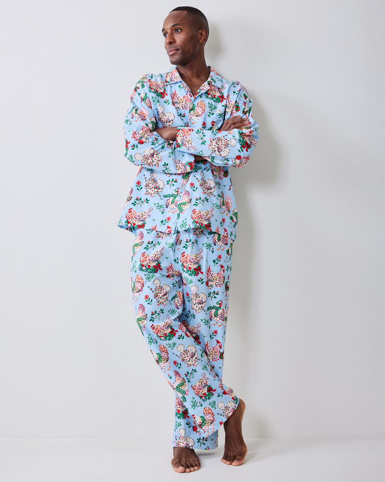 Full-length view of a pale blue holiday hen pajama set with a long-sleeve button-front shirt and pants.