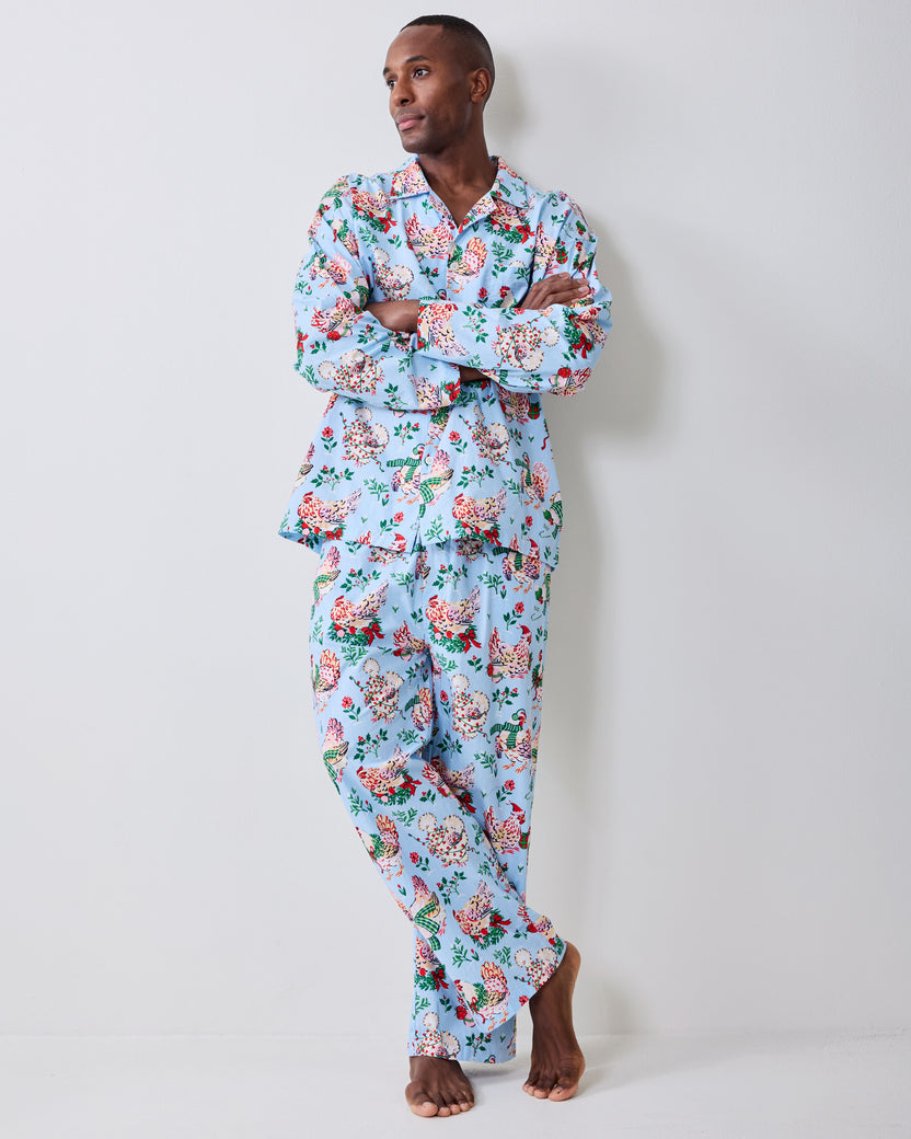 Full-length view of a pale blue holiday hen pajama set with a long-sleeve button-front shirt and pants.