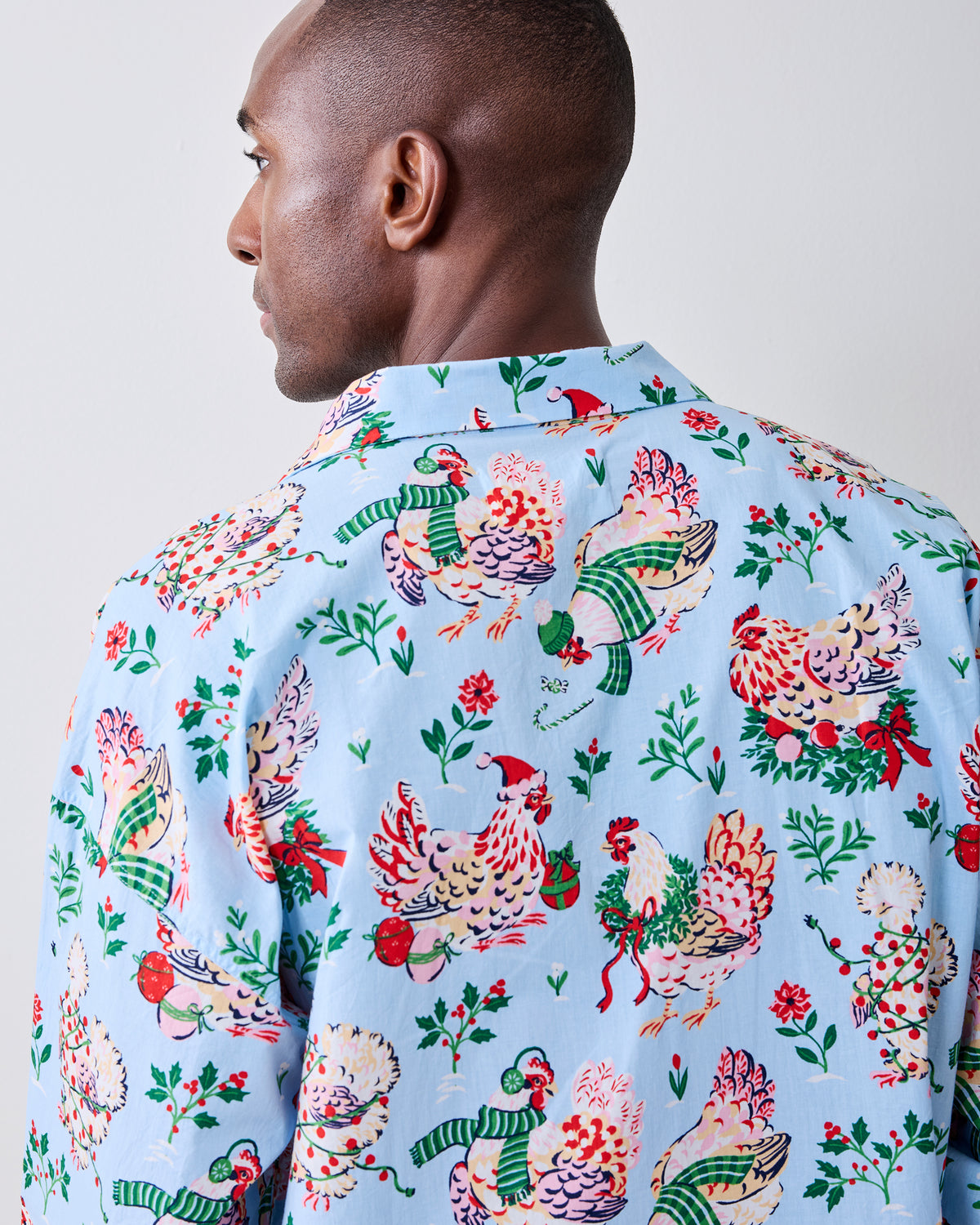 Back view of the pale blue holiday hen pajama shirt showing the all-over print and collar.